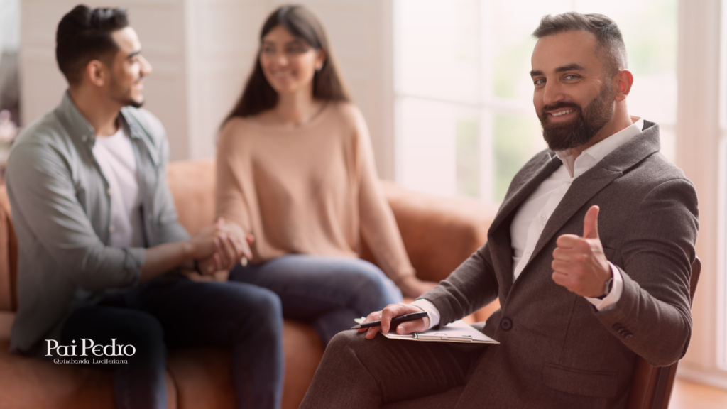 Casal sorridente em sessão de terapia de casal, com terapeuta ao fundo fazendo sinal positivo, simbolizando reconciliação e evolução emocional.