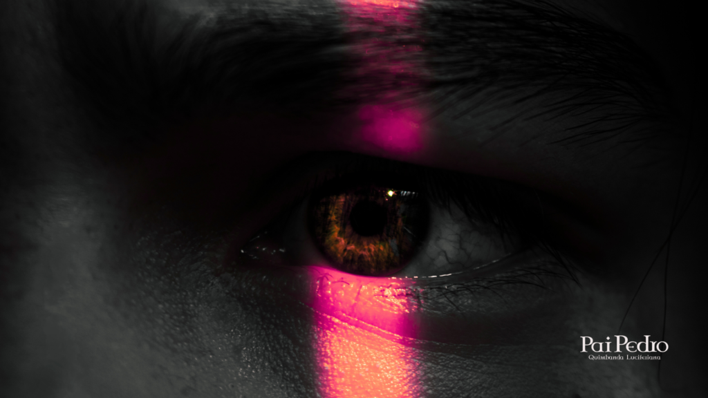 Olho humano em close-up, refletindo luz magenta vertical, simbolizando o despertar da consciência espiritual nas verdadeiras práticas religiosos, com destaque para a conexão profunda e ancestral presente na prática.