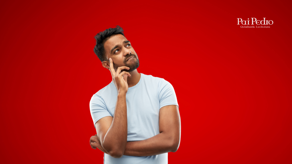Homem pensativo olhando para cima, com expressão de dúvida e incerteza, representando o que passa na cabeça de um homem quando ele pede um tempo no relacionamento. Ele veste camiseta clara e está sobre um fundo vermelho.