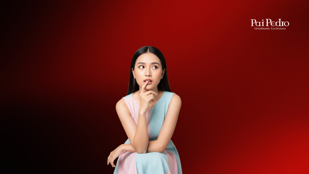 Mulher pensativa olhando para cima, com expressão de dúvida, sentada diante de um fundo vermelho intenso — representando o conflito interno entre amor verdadeiro e dependência emocional.