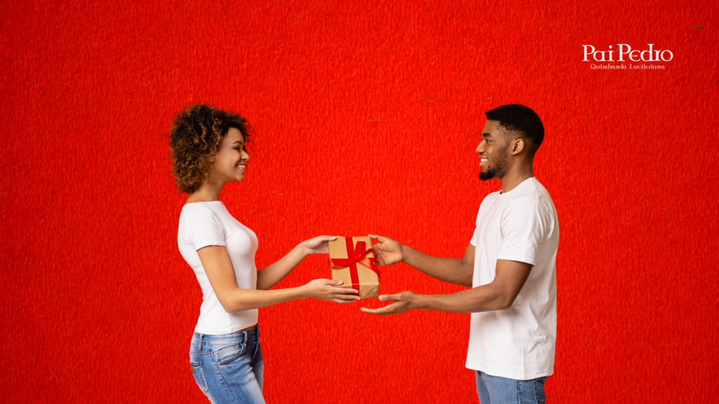 Casal sorrindo enquanto ela entrega um presente embrulhado com laço vermelho para o parceiro. A cena ilustra como surpreender namorado com presente simples, pensado com carinho e sem depender de datas especiais.