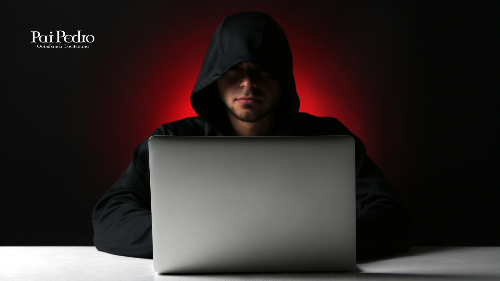 Pessoa usando um moletom com capuz preto, parcialmente iluminada pela luz vermelha ao fundo, digitando em um notebook prateado sobre uma mesa. A cena transmite mistério e tensão, remetendo à investigação e exposição de um tema sensível relacionado à fé, estelionato religioso e manipulação.