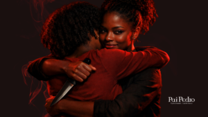 Duas mulheres se abraçando em clima tenso, com expressão ambígua e luz vermelha dramática, simbolizando amiga falsa: proximidade aparente, intenção oculta e traição disfarçada de afeto.