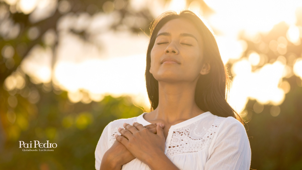 Mulher ao ar livre com olhos fechados e mãos sobre o peito, respirando profundamente, simbolizando libertação da preocupação excessiva e reconexão com o presente.