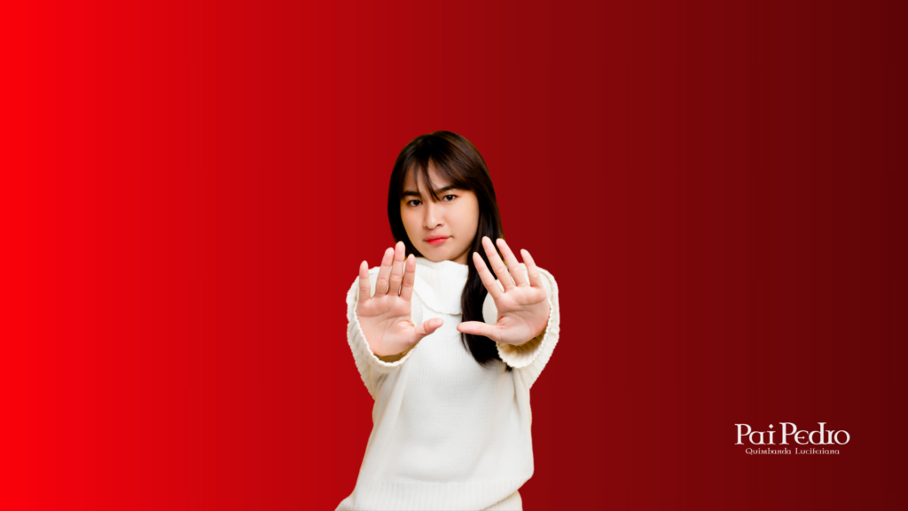 Mulher com expressão firme fazendo gesto de limite com as mãos à frente, simbolizando decisão, proteção emocional e afastamento consciente de amiga falsa e comportamentos invejosos.