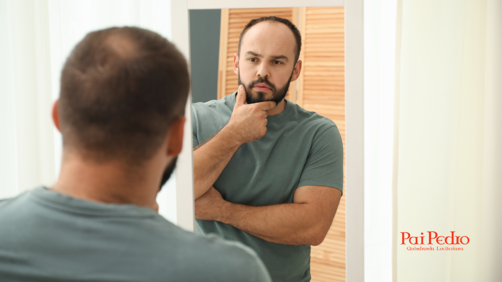 Homem observando o próprio reflexo no espelho com expressão séria e postura introspectiva, representando comportamento narcisista e foco excessivo na autoimagem.