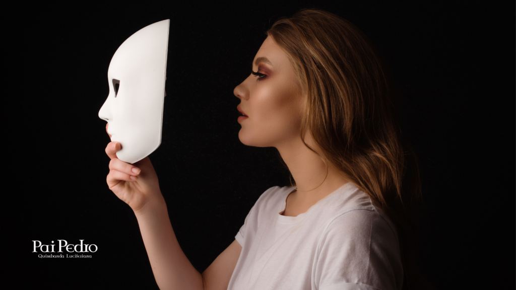 Mulher segurando uma máscara branca diante do rosto em fundo escuro, simbolizando sofrimento escondido e os sinais silenciosos da solidão crônica.