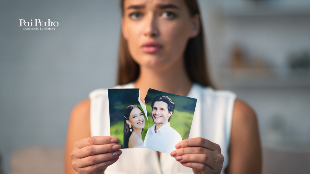 Mulher segurando uma foto rasgada do casal, representando o fim de um relacionamento e o impacto emocional de um ex-amor