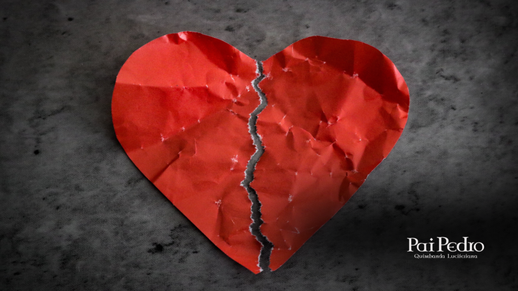 Imagem sobre pós término com um coração vermelho de papel rasgado ao meio sobre fundo escuro, simbolizando dor emocional, separação e reconstrução após o fim de um relacionamento.