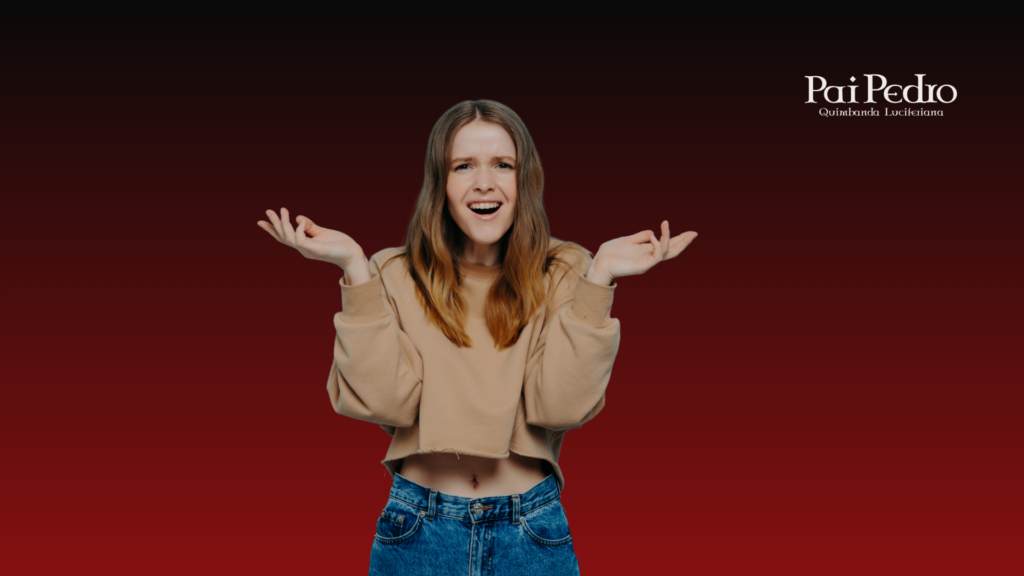 Mulher com expressão confusa e mãos levantadas sobre fundo vermelho escuro, representando a Ingenuidade de quem continua acreditando demais mesmo diante de sinais contraditórios no amor.