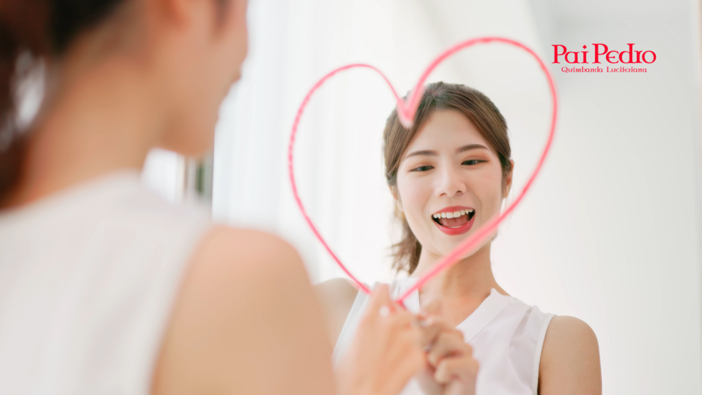 Amor: mulher sorrindo para o próprio reflexo enquanto desenha um coração no espelho, simbolizando carinho, autoestima e reconexão consigo mesma.